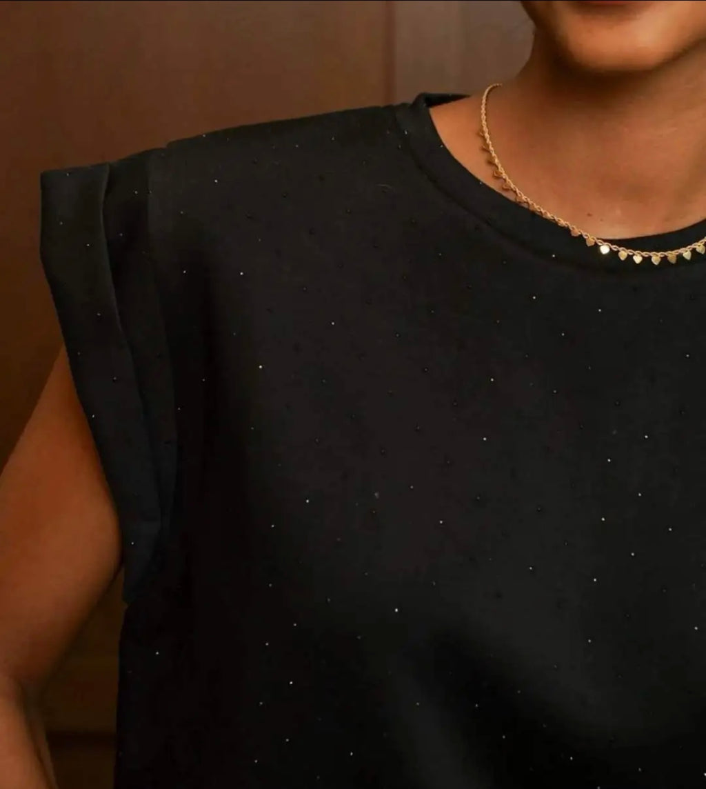 Detalle de la camiseta Black Shine negra con microbrillos, cuello redondo y hombro estructurado